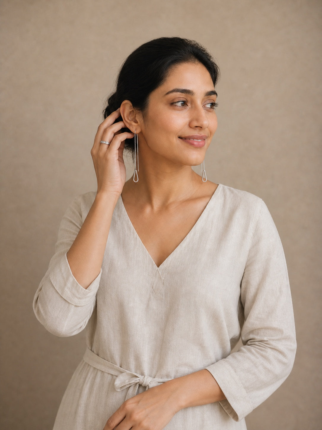 Woman wearing Uncle Jewels silver thread earrings and a ring