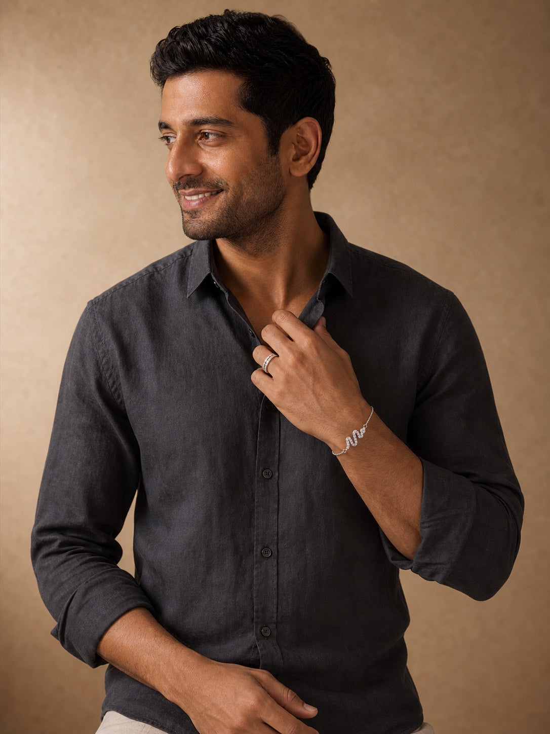 Man wearing Uncle Jewels silver ring and snake bracelet