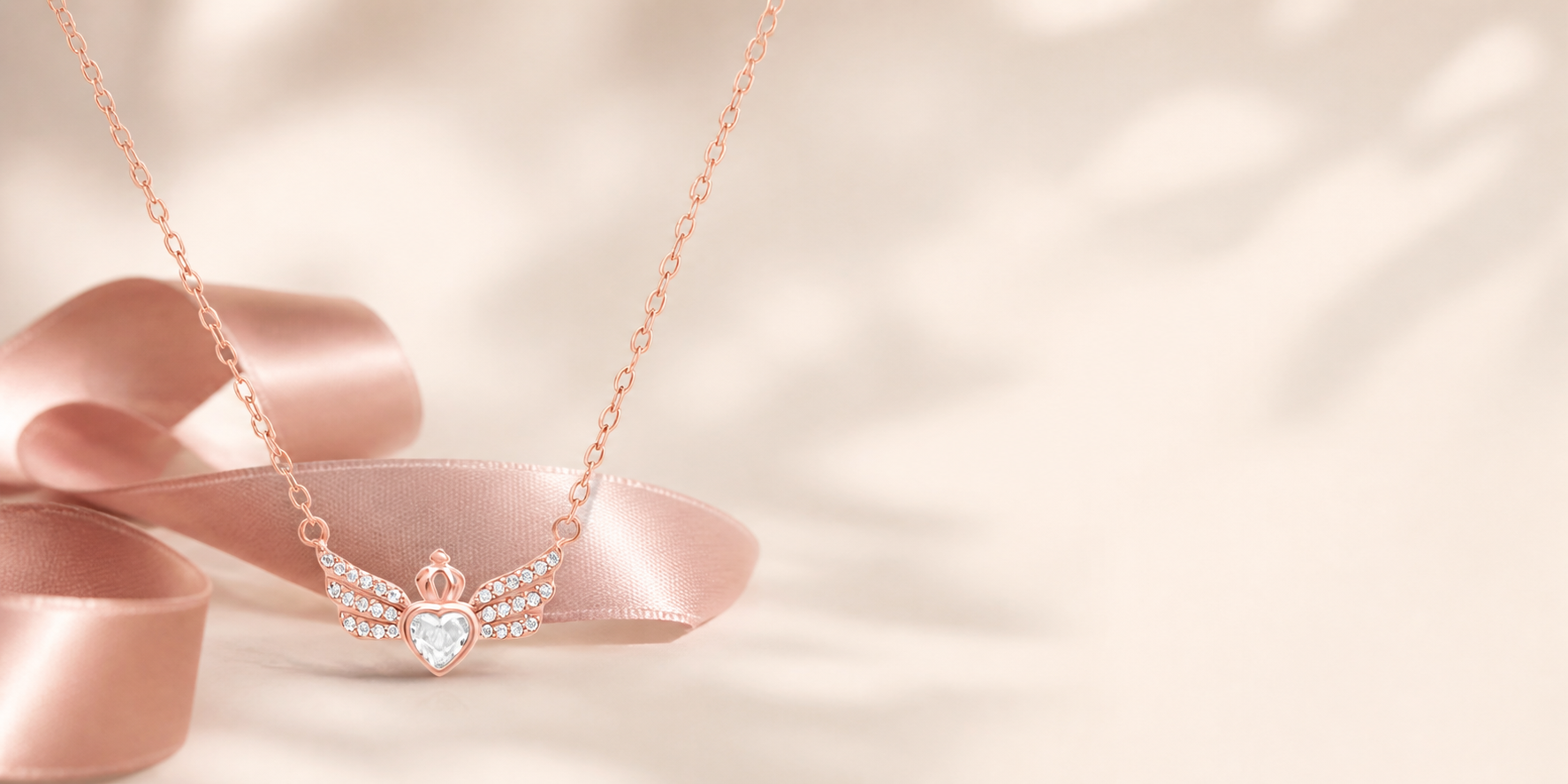 Rose gold heart and crown necklace with a dusty rose ribbon