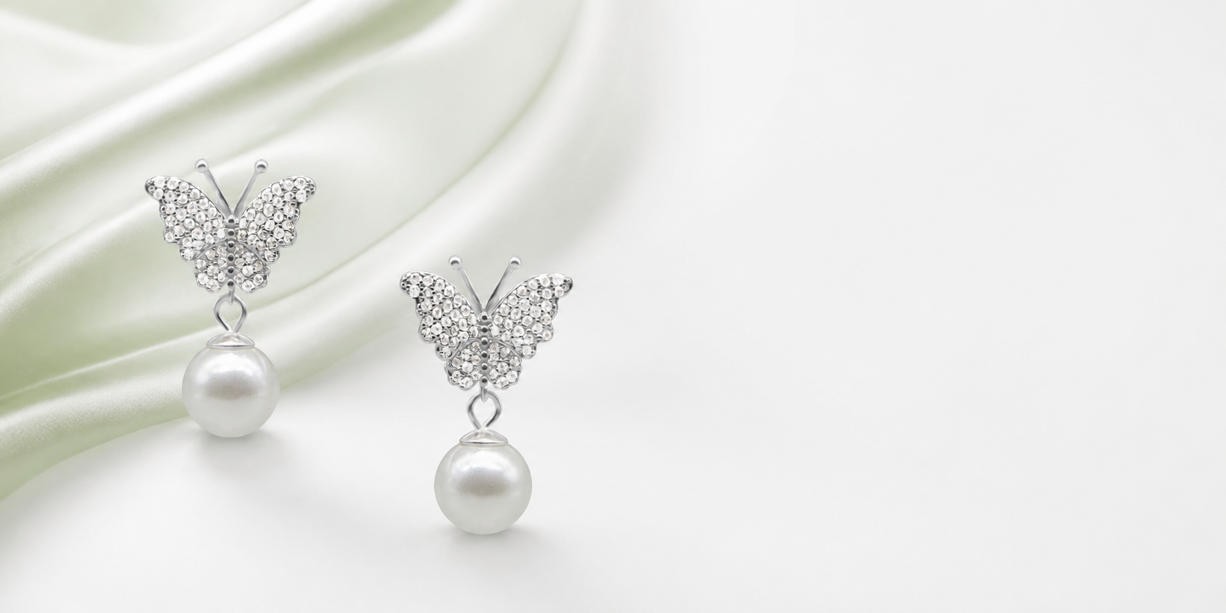 Silver butterfly pearl earrings on pearl white and soft sage